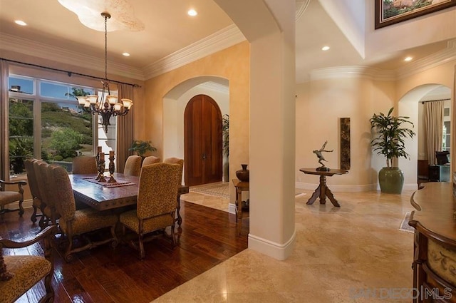 dining room with hardwood / wood-style flooring, crown molding, and a chandelier