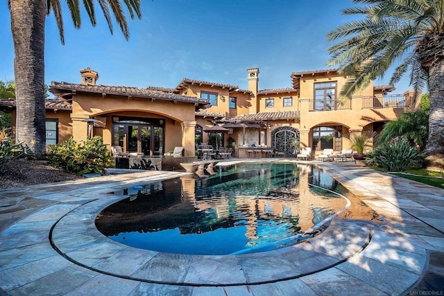 rear view of house featuring a balcony and a patio area