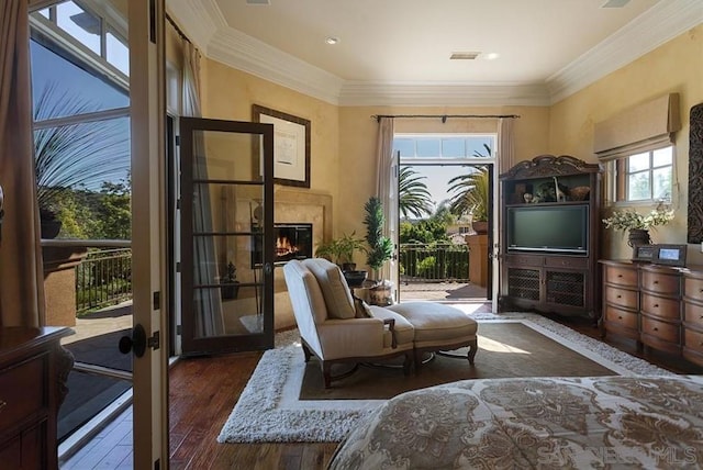 living area featuring a premium fireplace, dark wood-type flooring, crown molding, and french doors