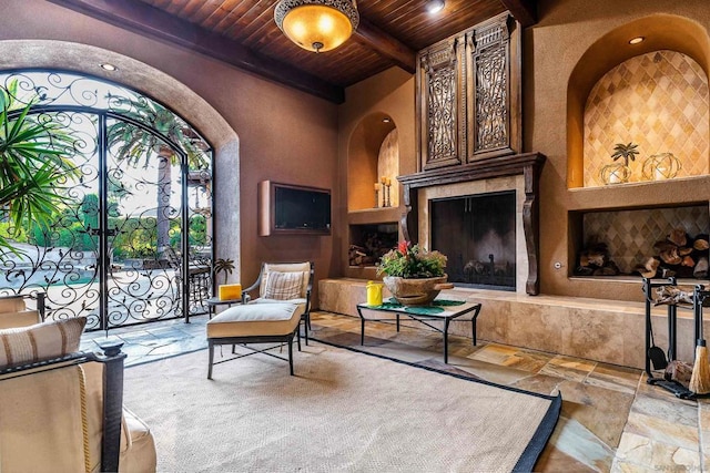 sitting room featuring a premium fireplace, beam ceiling, and wooden ceiling