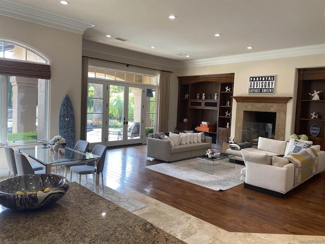 living room with a premium fireplace, ornamental molding, and hardwood / wood-style flooring