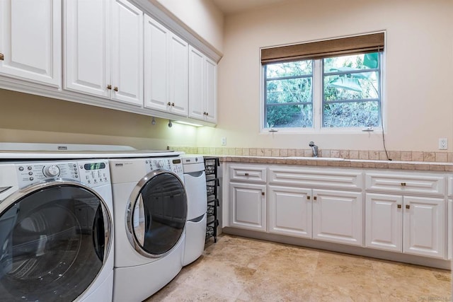 laundry room with cabinets, sink, and independent washer and dryer