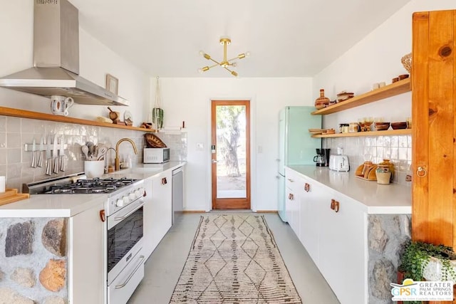 kitchen featuring wall chimney exhaust hood, sink, tasteful backsplash, white appliances, and white cabinets