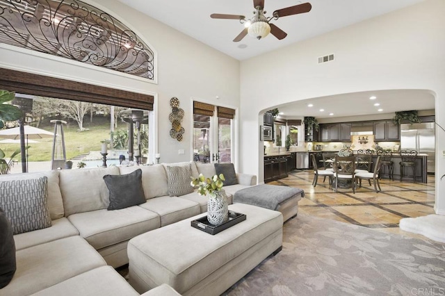 living room featuring a towering ceiling and ceiling fan