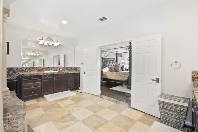 bathroom featuring decorative columns and vanity