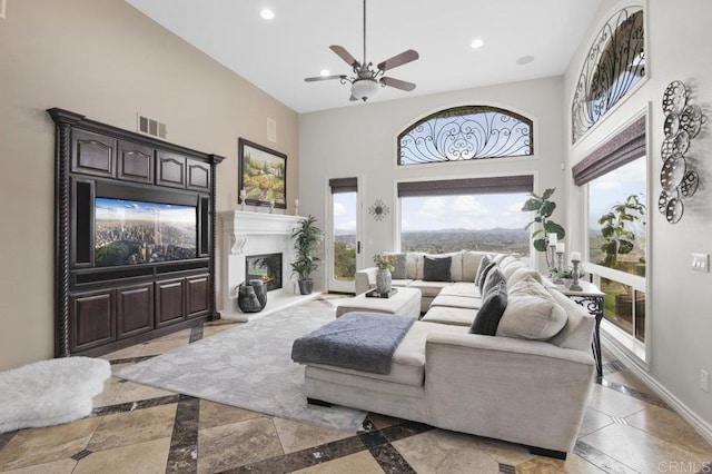 living room featuring ceiling fan and a towering ceiling