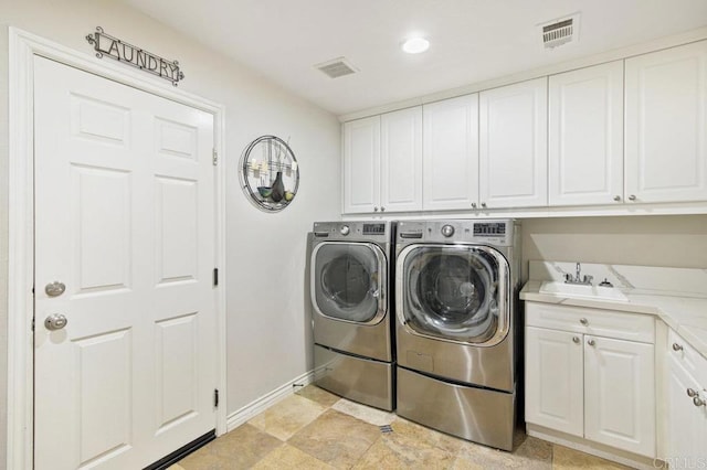 laundry area featuring cabinets, washer and clothes dryer, and sink