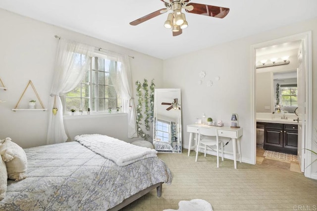 carpeted bedroom with ceiling fan and ensuite bath