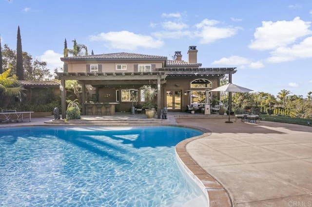 view of swimming pool featuring a pergola, a patio, and exterior bar