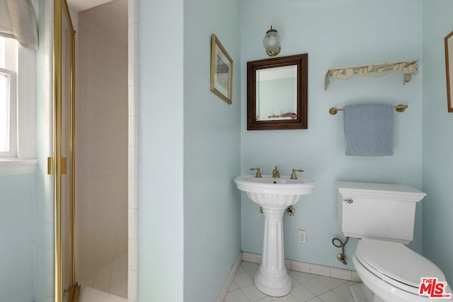 bathroom featuring tile patterned floors, toilet, and a shower with shower door