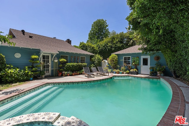 view of pool featuring an outdoor structure and a patio area