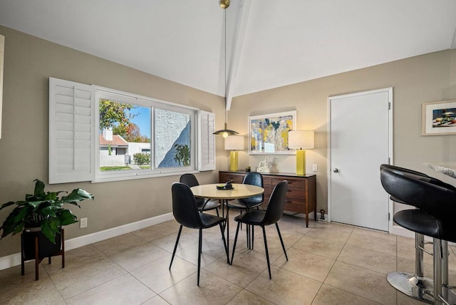 tiled dining space featuring lofted ceiling