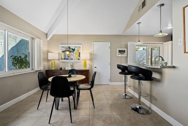 tiled dining space with vaulted ceiling