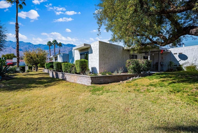 exterior space with a mountain view and a front yard