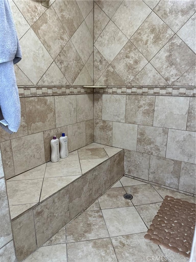 interior details with a tile shower