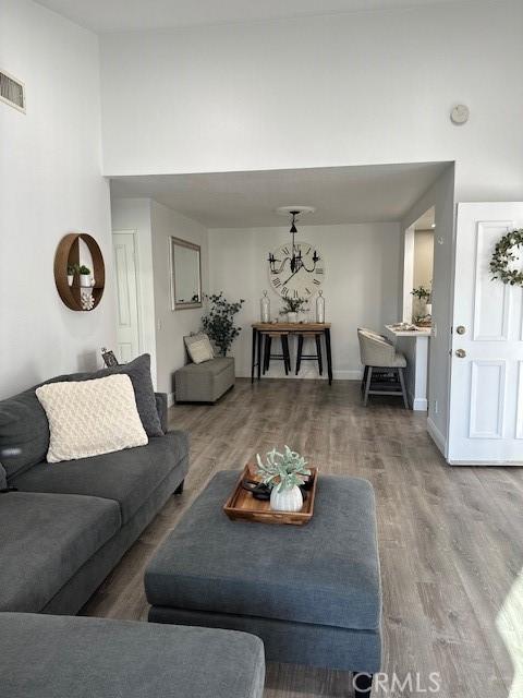 living room with a high ceiling and wood-type flooring