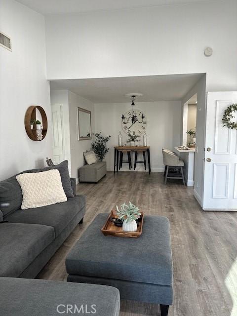 living room with a high ceiling and wood-type flooring