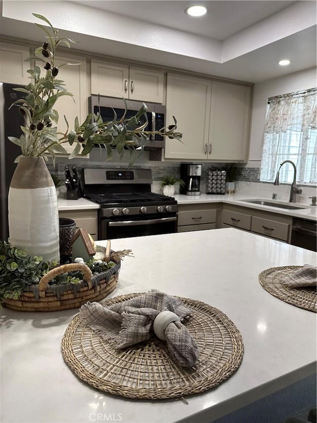 kitchen featuring stainless steel appliances, tasteful backsplash, sink, and gray cabinets