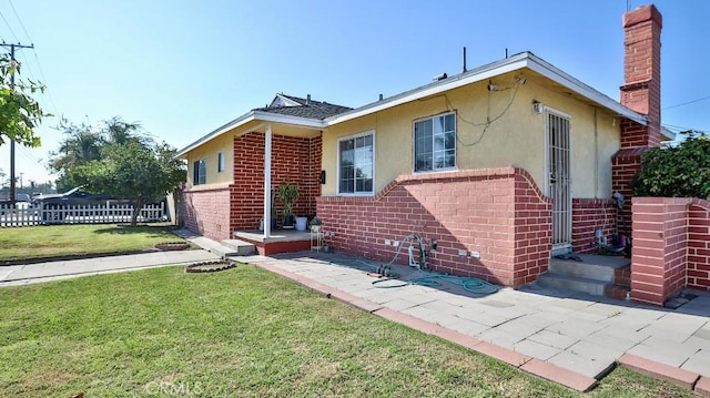 view of front of home featuring a patio and a front lawn