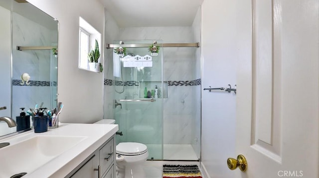 bathroom featuring vanity, toilet, and an enclosed shower