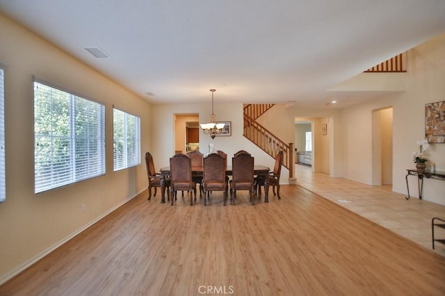 dining space featuring light hardwood / wood-style floors and a chandelier