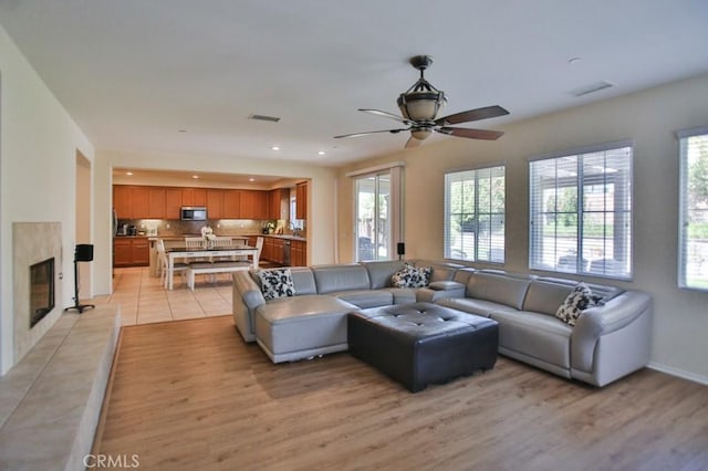 living room with a wealth of natural light, a premium fireplace, and light wood-type flooring