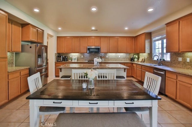 kitchen featuring light stone counters, sink, light tile patterned flooring, and appliances with stainless steel finishes