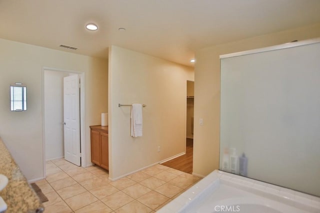 bathroom featuring vanity, tile patterned floors, and a bathing tub