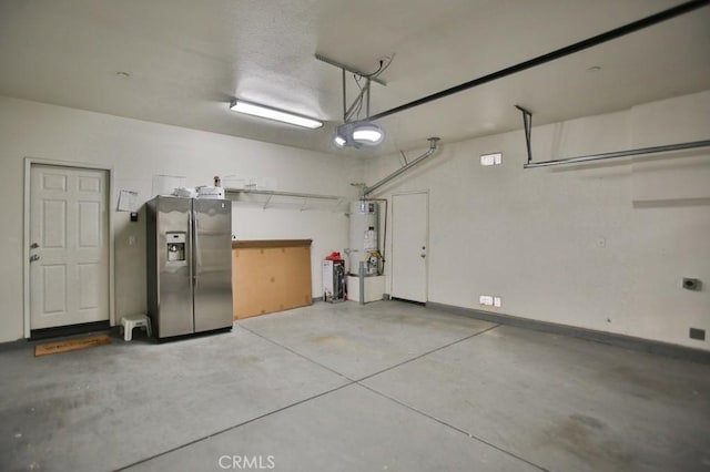 garage with a garage door opener, water heater, and stainless steel refrigerator with ice dispenser