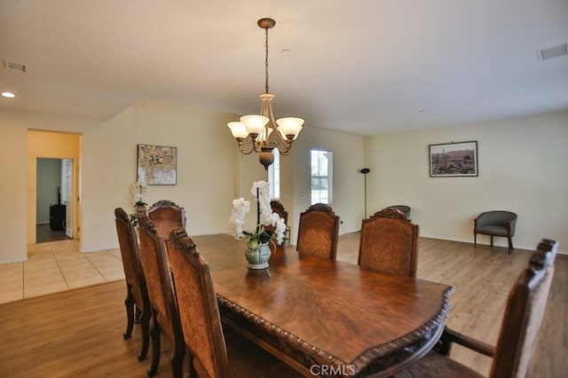 dining space with an inviting chandelier and light wood-type flooring