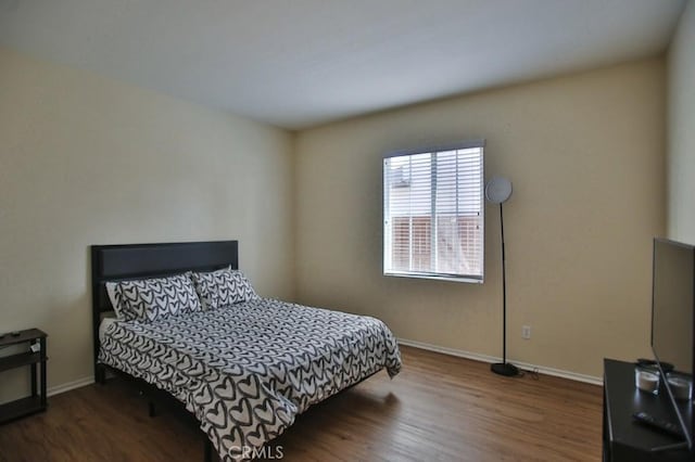 bedroom with dark hardwood / wood-style floors