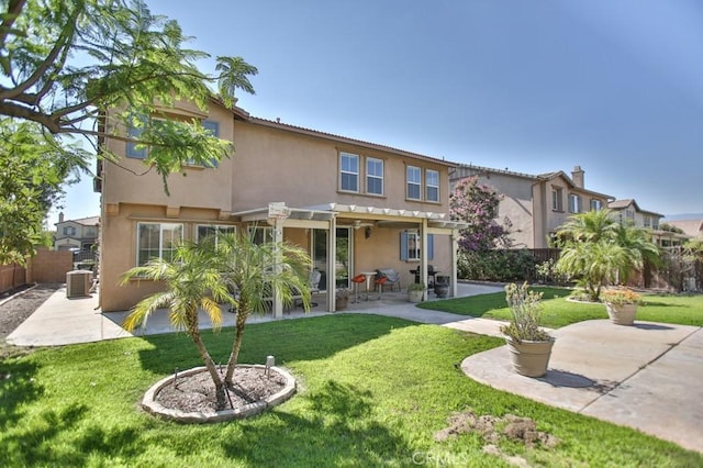 back of property with a pergola, a lawn, and a patio