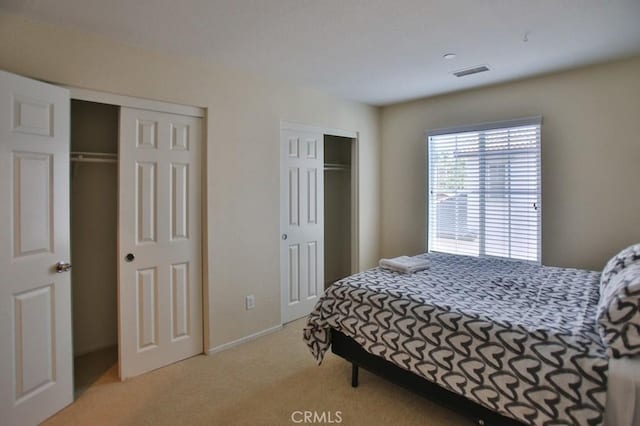 carpeted bedroom with multiple closets