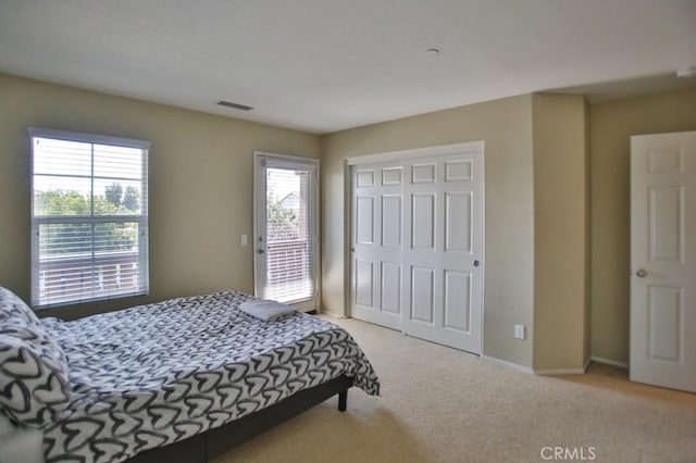 bedroom with light colored carpet and a closet