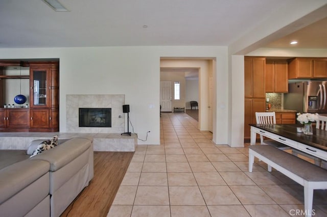 living room featuring a tile fireplace and light tile patterned floors