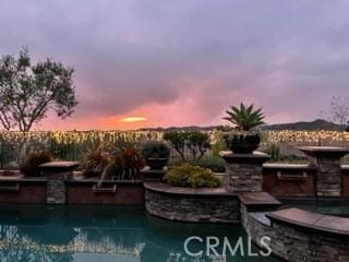 view of pool at dusk