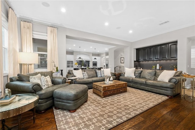 living room featuring dark wood-type flooring and ornamental molding