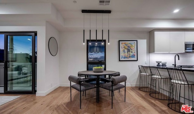 dining space with sink and light hardwood / wood-style flooring