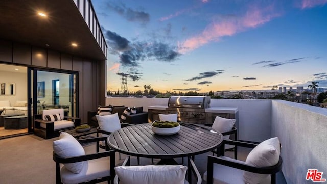 patio terrace at dusk featuring a balcony