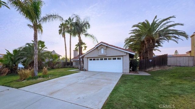 view of front of home with a garage and a yard