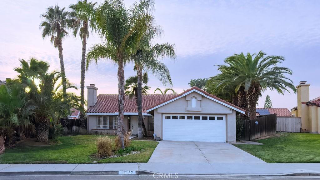 view of front of property featuring a garage and a lawn