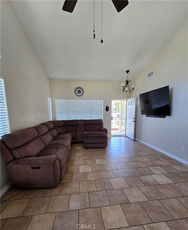 living area featuring visible vents, baseboards, high vaulted ceiling, and ceiling fan with notable chandelier