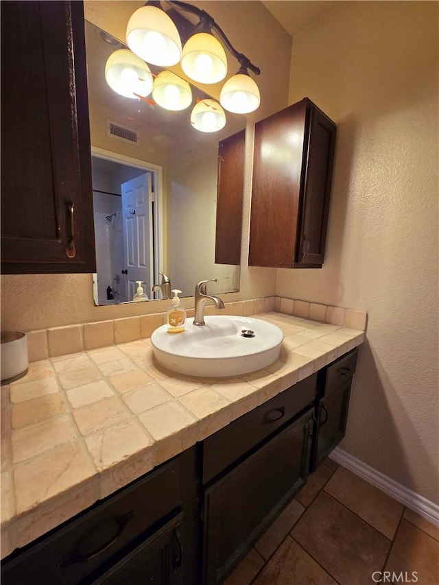 bathroom with tile patterned flooring, visible vents, vanity, and baseboards