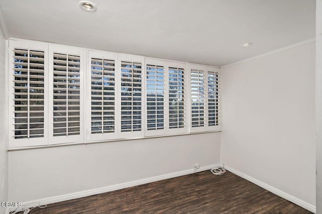 spare room with dark hardwood / wood-style flooring and crown molding