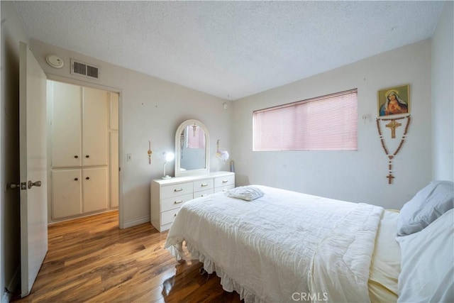 bedroom with wood-type flooring and a textured ceiling