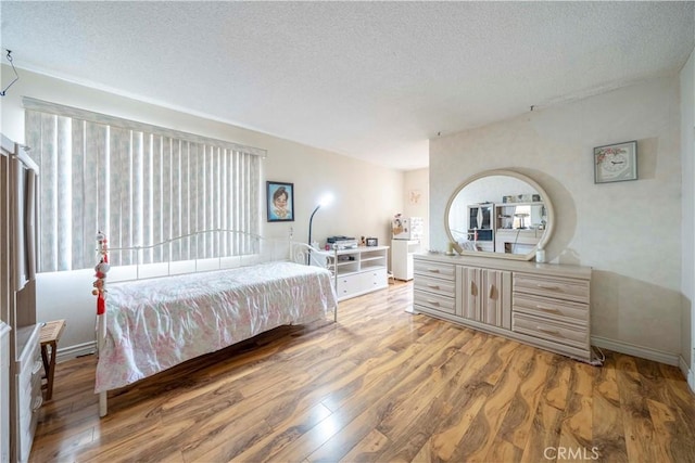 bedroom with wood-type flooring and a textured ceiling