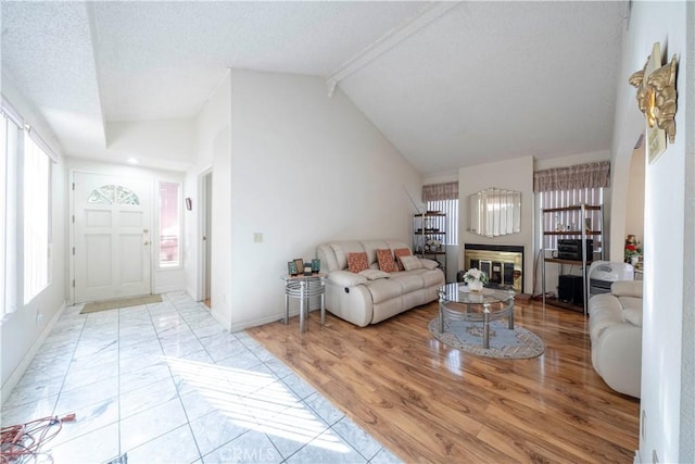 living room featuring high vaulted ceiling, beam ceiling, and light hardwood / wood-style floors