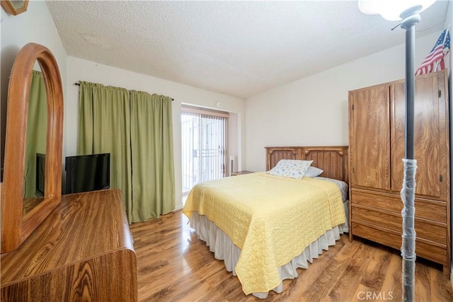 bedroom featuring a textured ceiling and light hardwood / wood-style floors