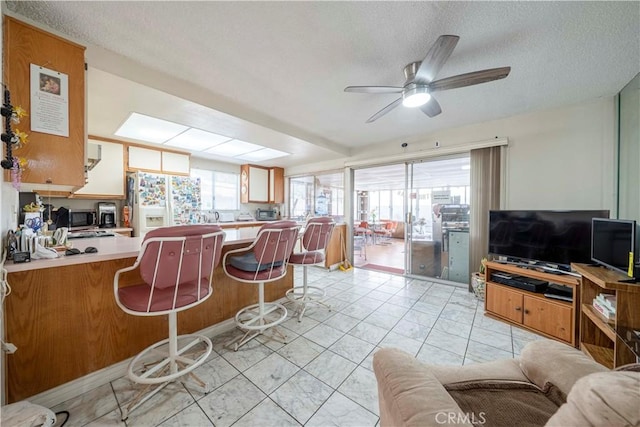 kitchen featuring white refrigerator with ice dispenser, a textured ceiling, and plenty of natural light