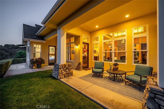 patio terrace at dusk featuring a yard